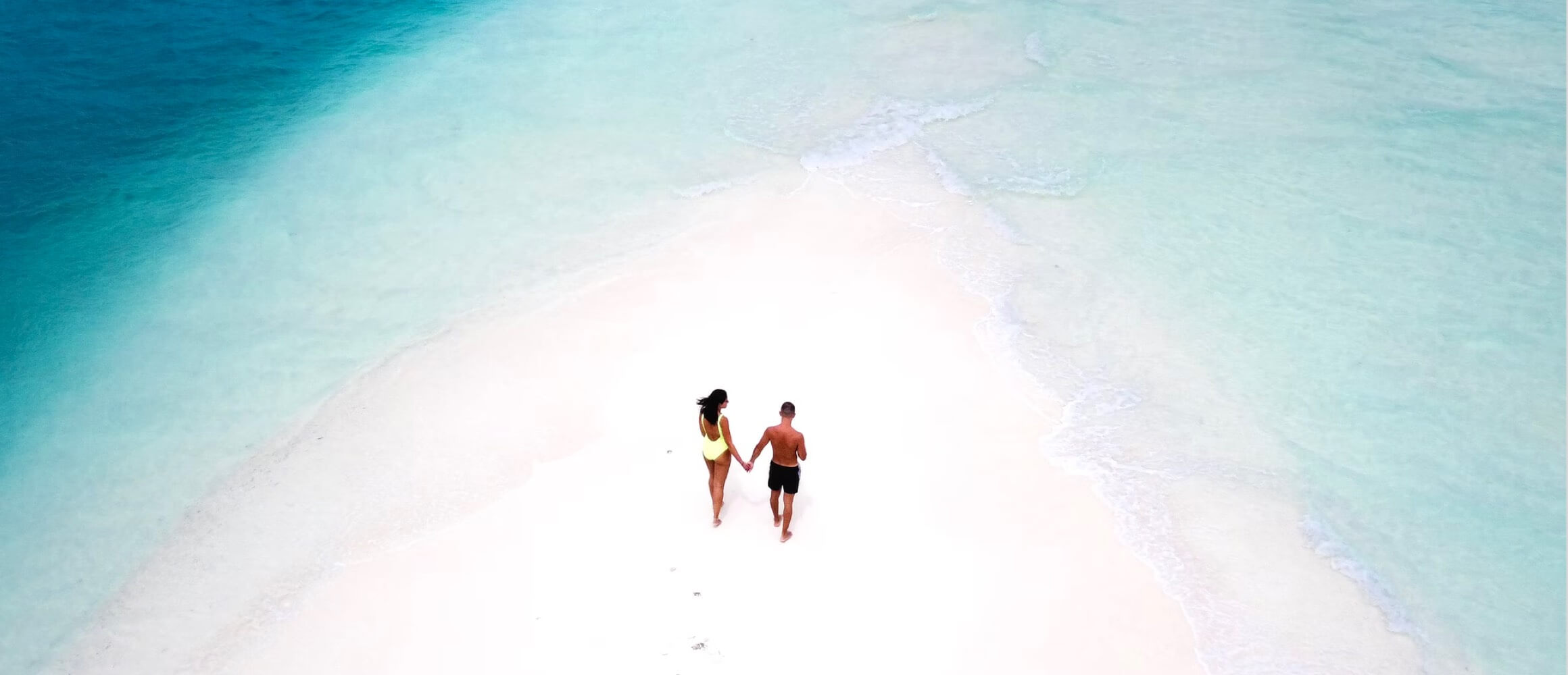 Two people on a tropical island in the middle of the ocean