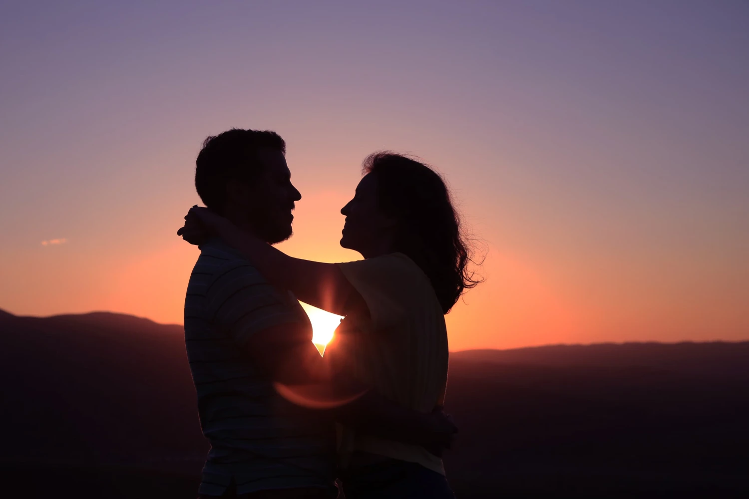 A couple kissing at sunset