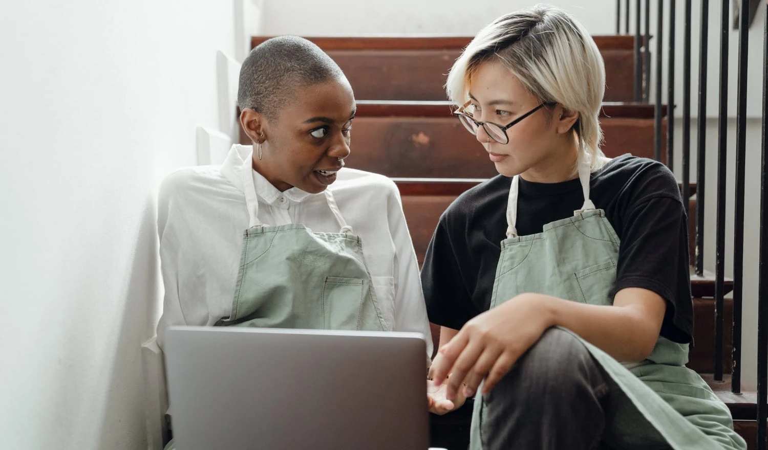 Two people browsing a laptop