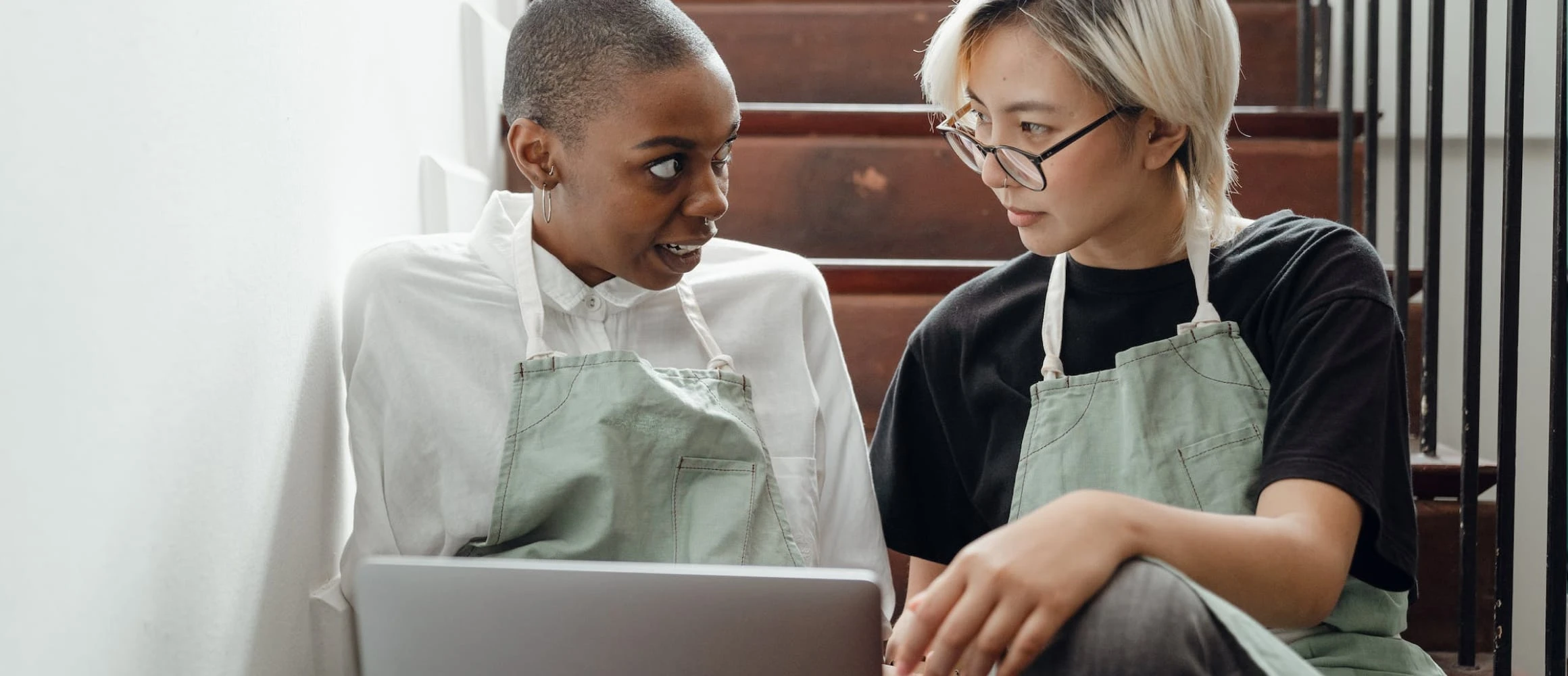 Two people browsing a laptop