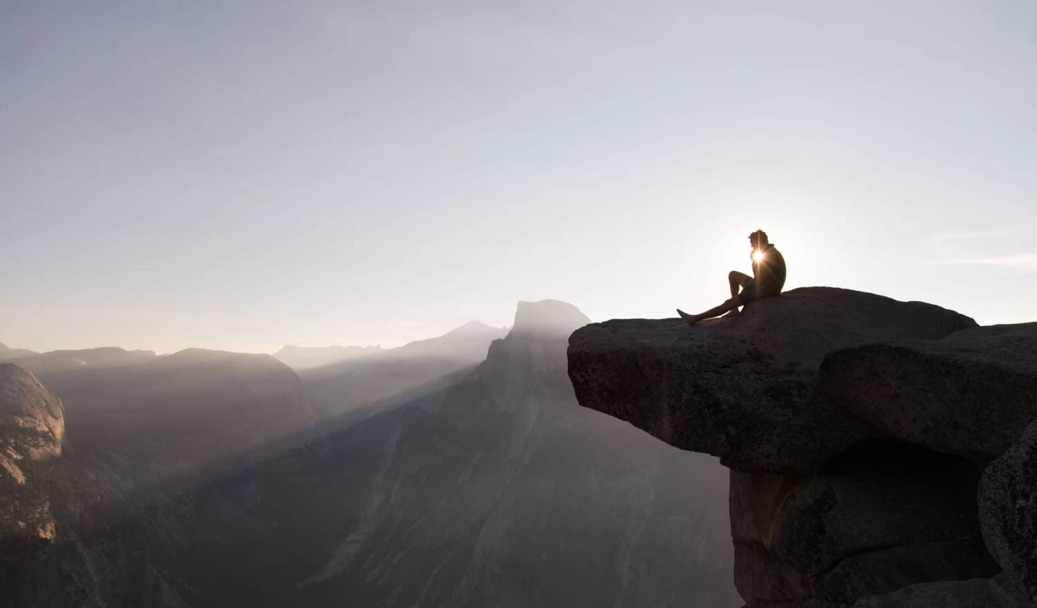 A man sitting on the edge of a cliff