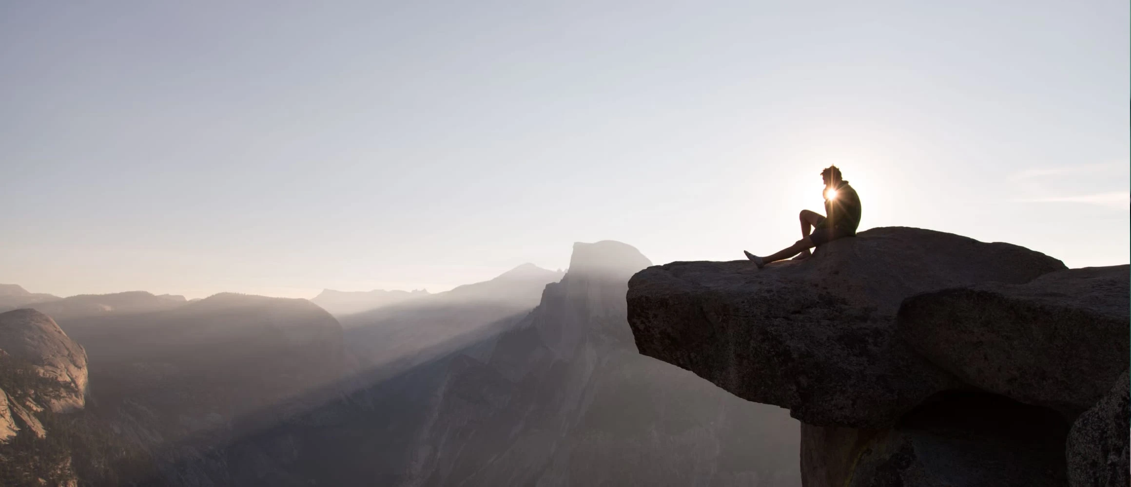 A man sitting on the edge of a cliff