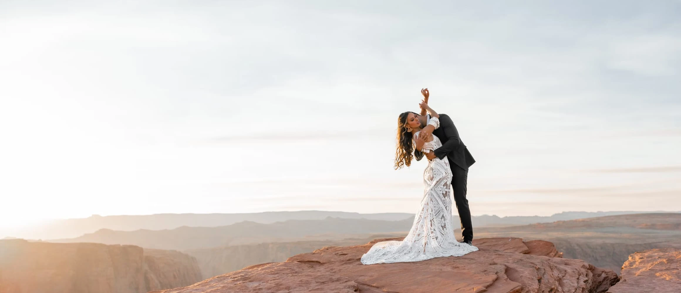 A newly married couple standing on a rock