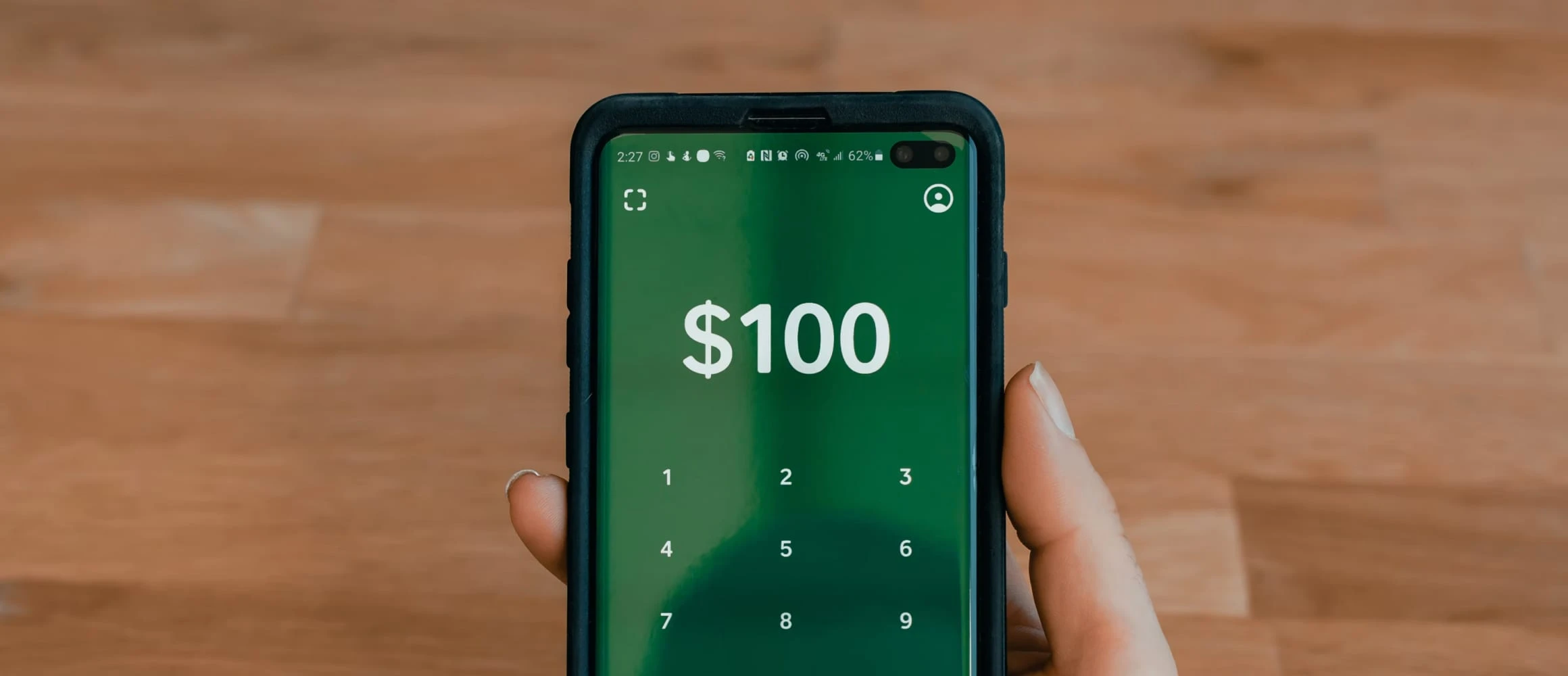 A woman holding a phone showing the Cash App