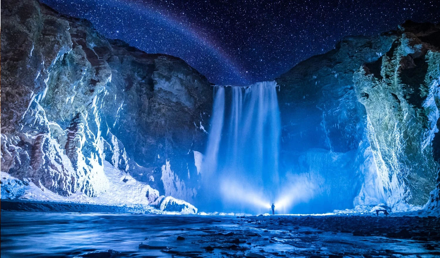 Person in front of waterfalls during night time
