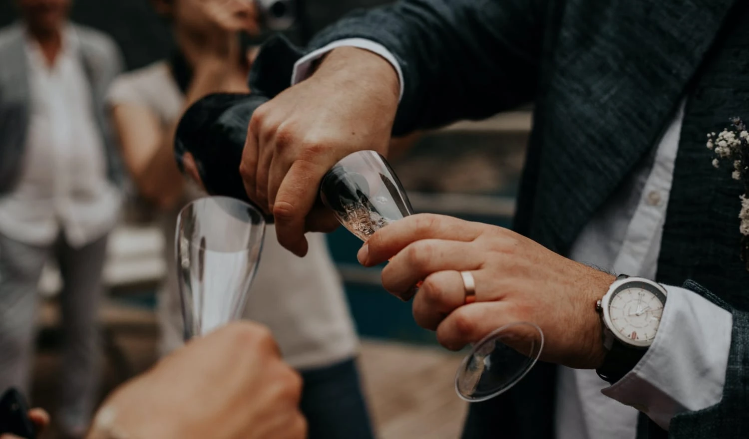 A man pouring another person a glass of champagne