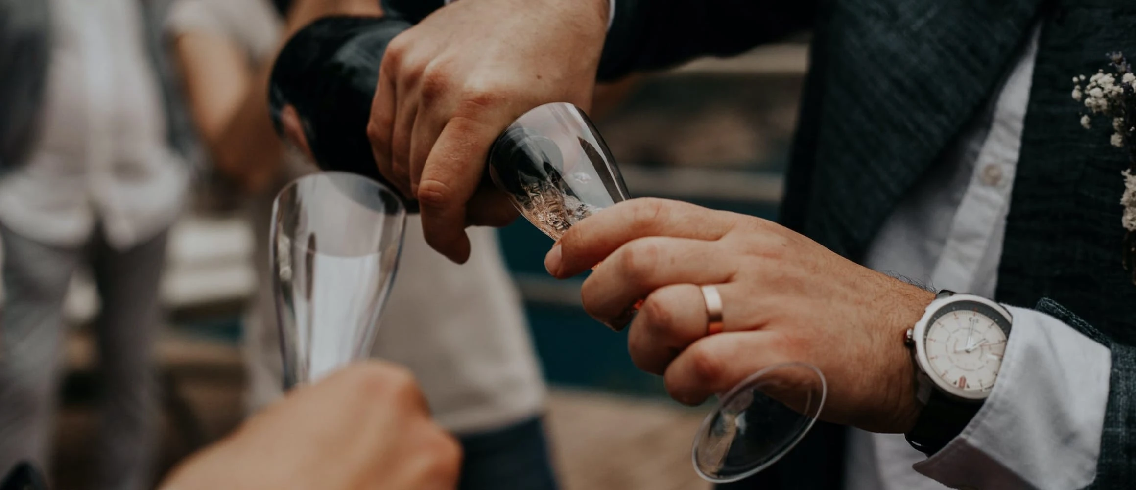 A man pouring another person a glass of champagne