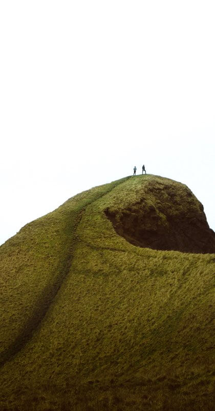 A couples standing on the peak of a mountain