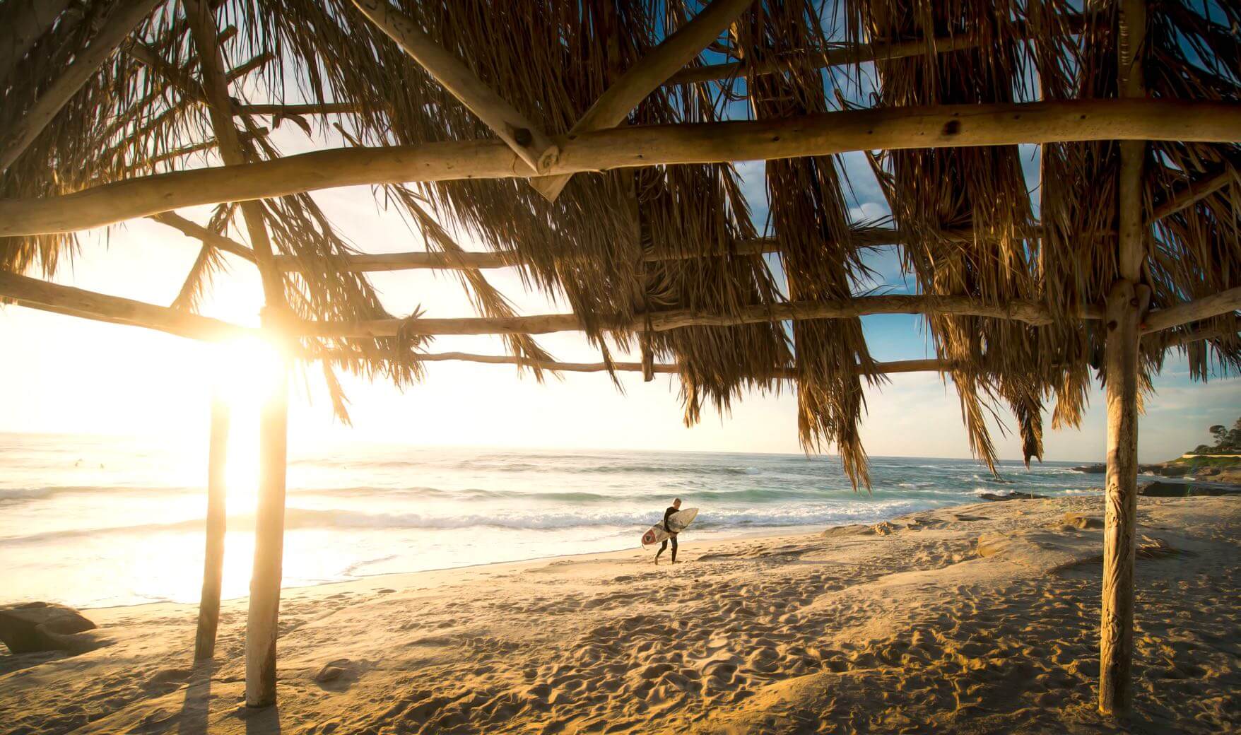 A surfer hitting the sand at sunset