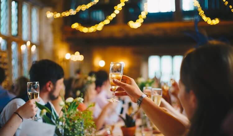 Happy wedding guests chinking their champagne glasses