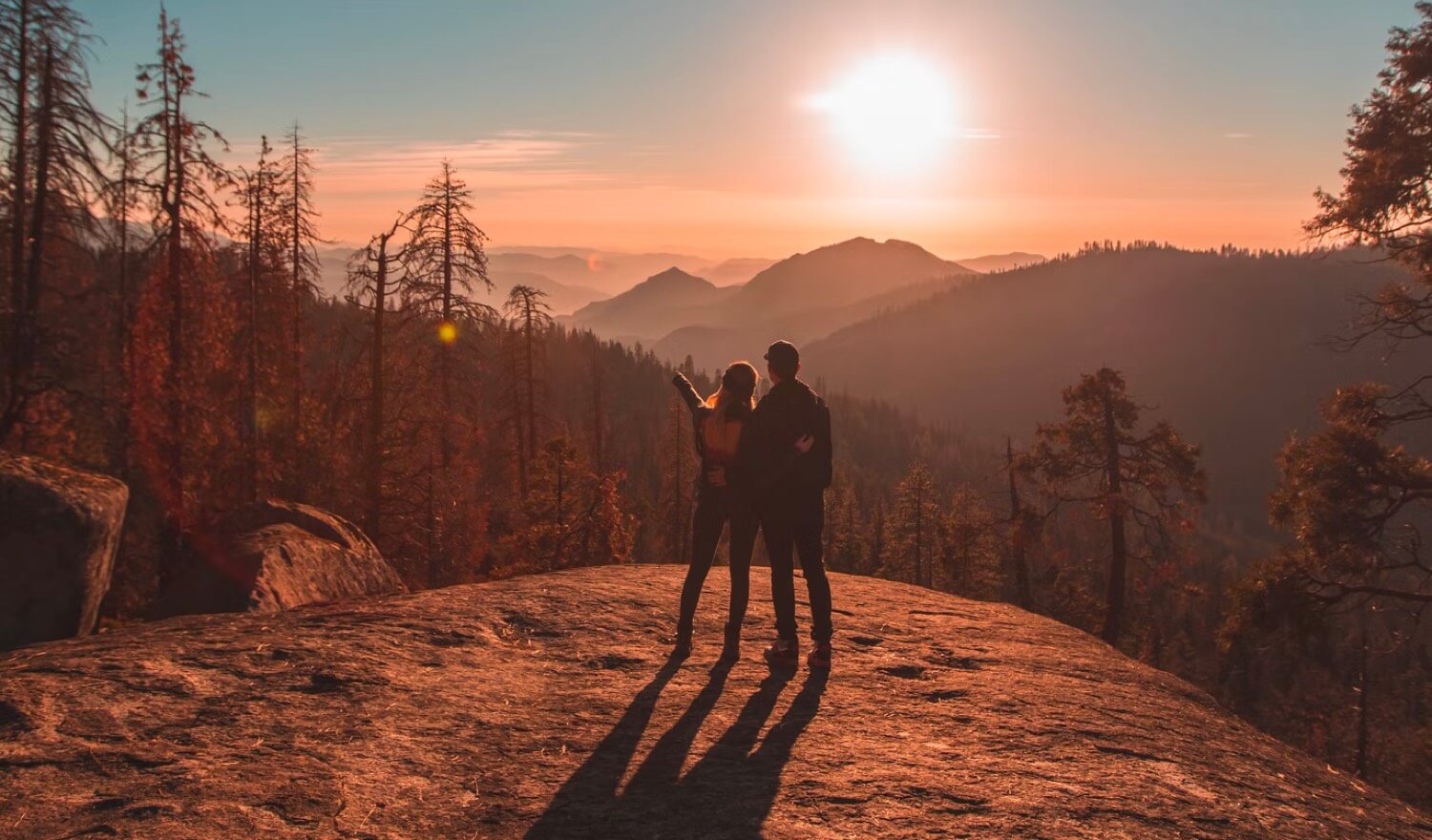 A couple standing in front of a sunset