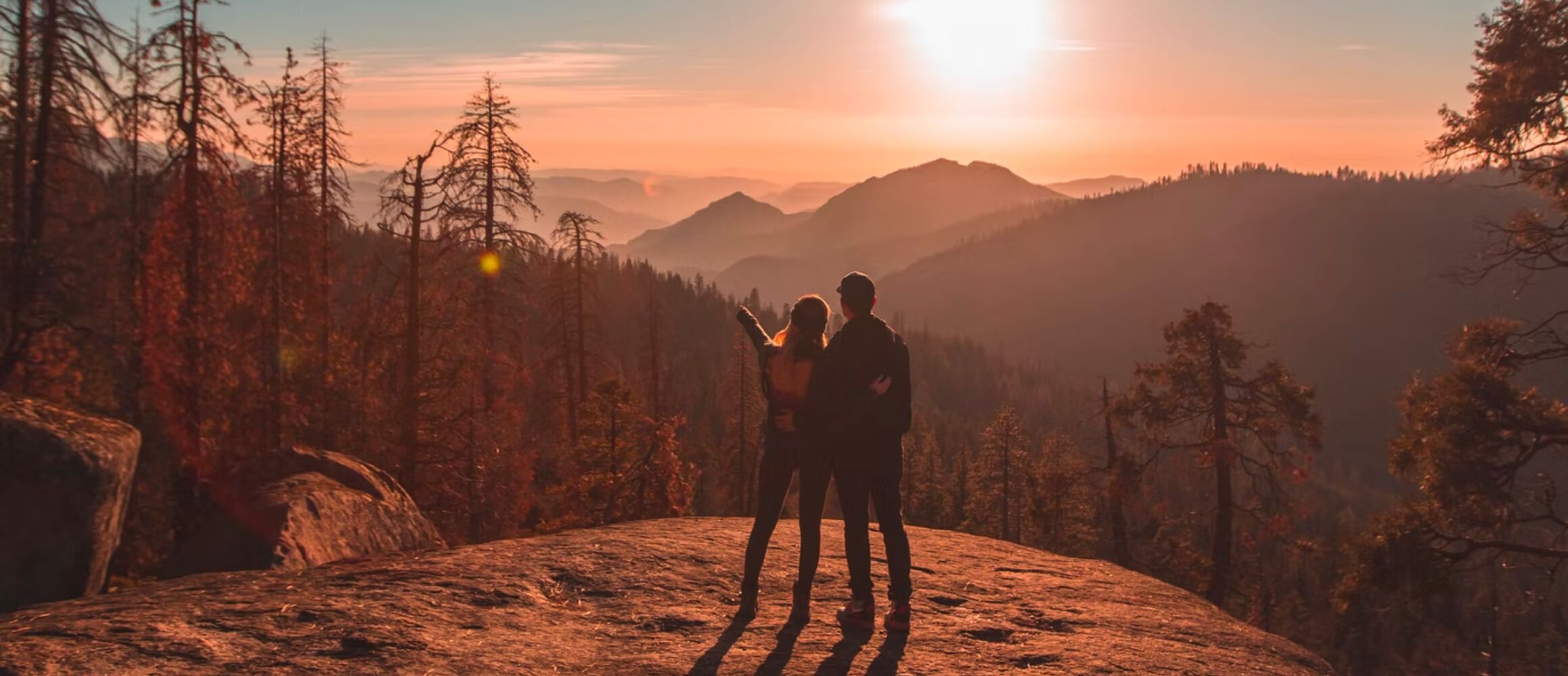 A couple standing in front of a sunset