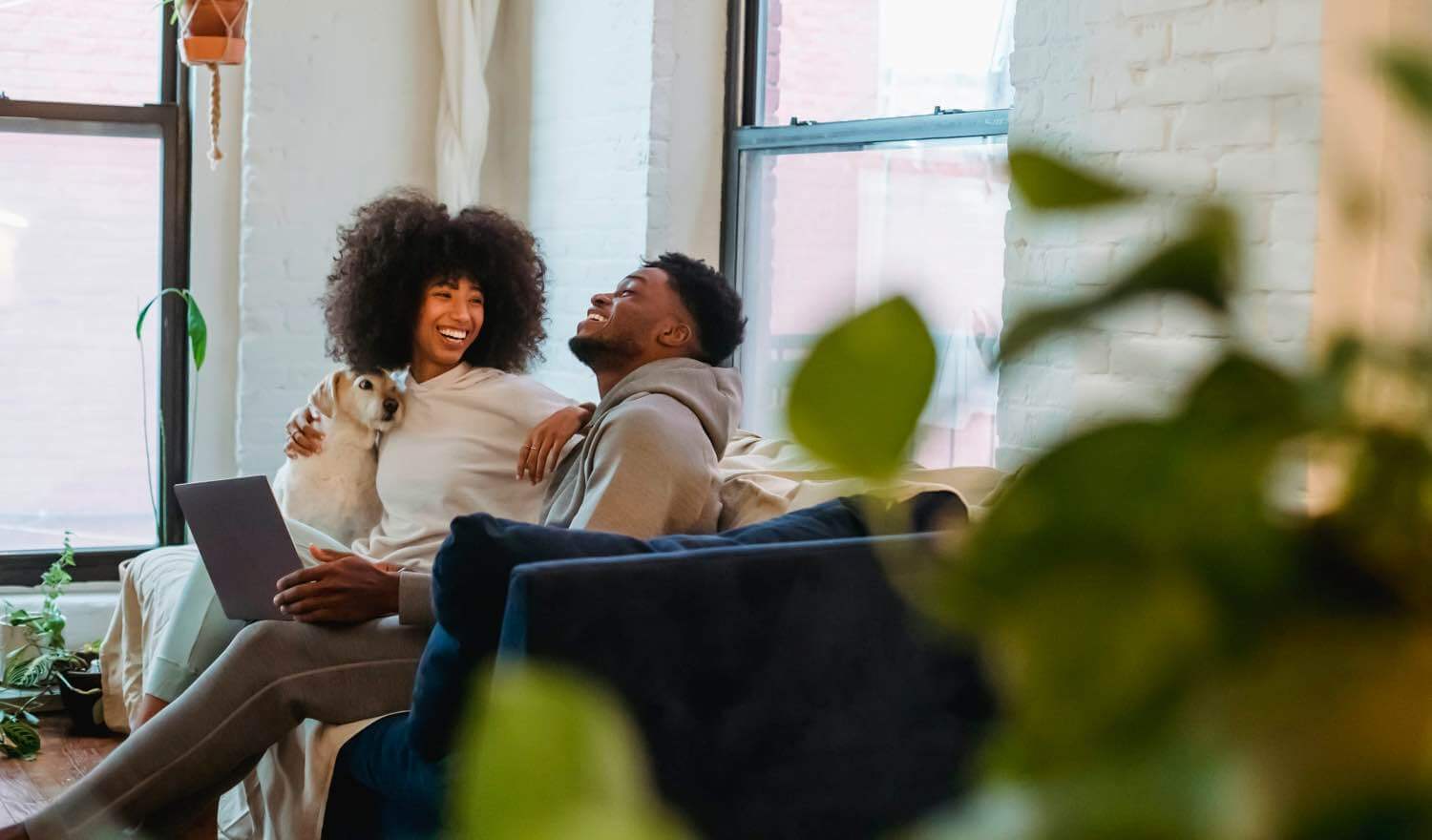 Two people laughing on a couch