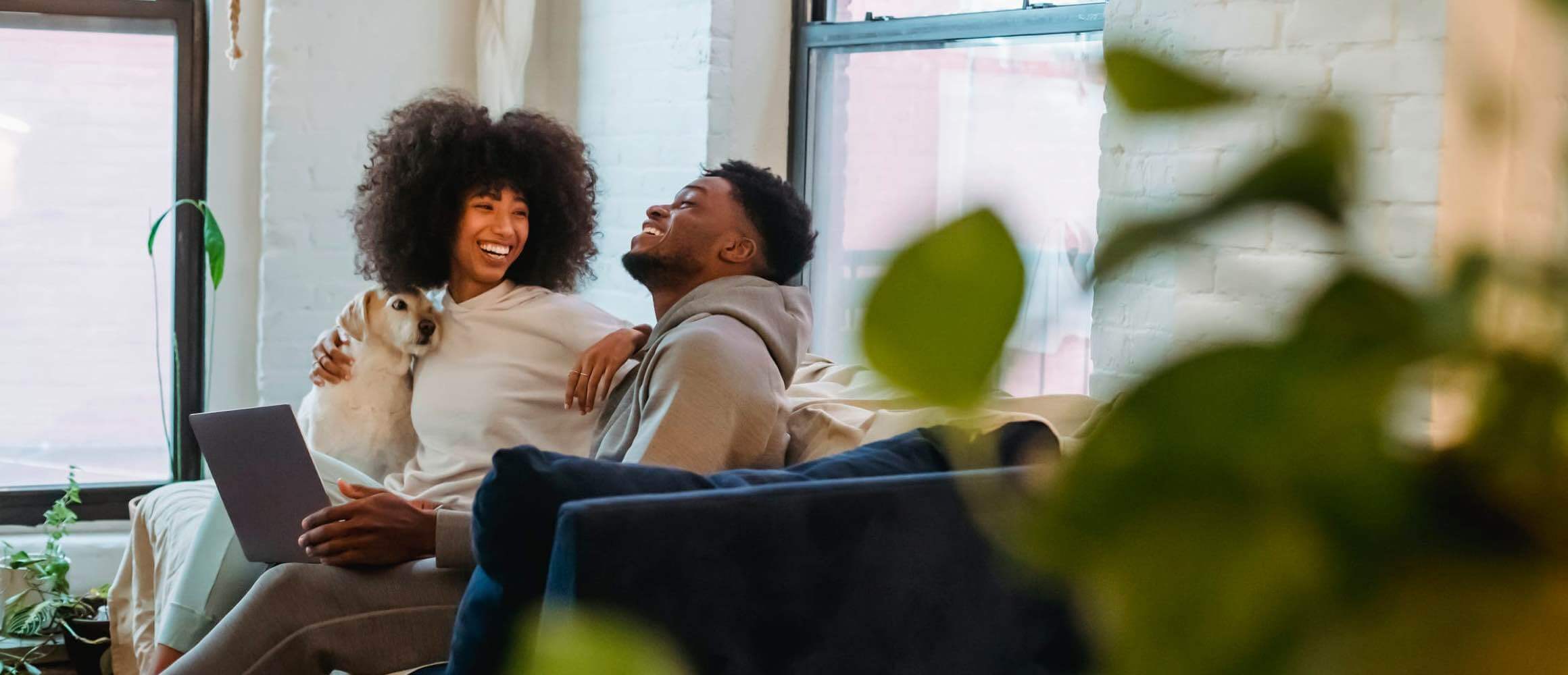 Two people laughing on a couch