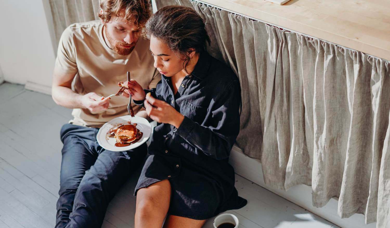 A couple eating pancakes in their kitchen