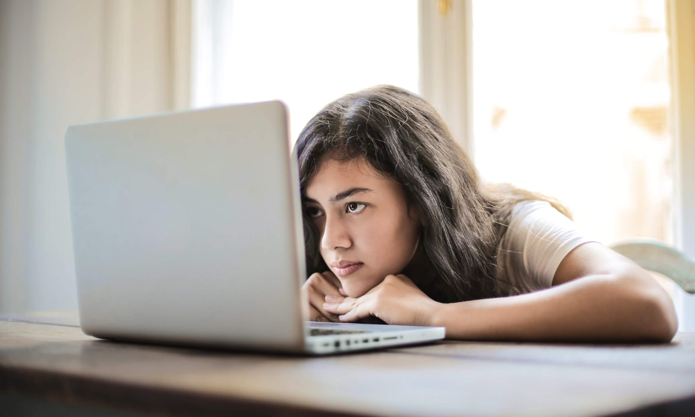 A womam crouching over her laptop