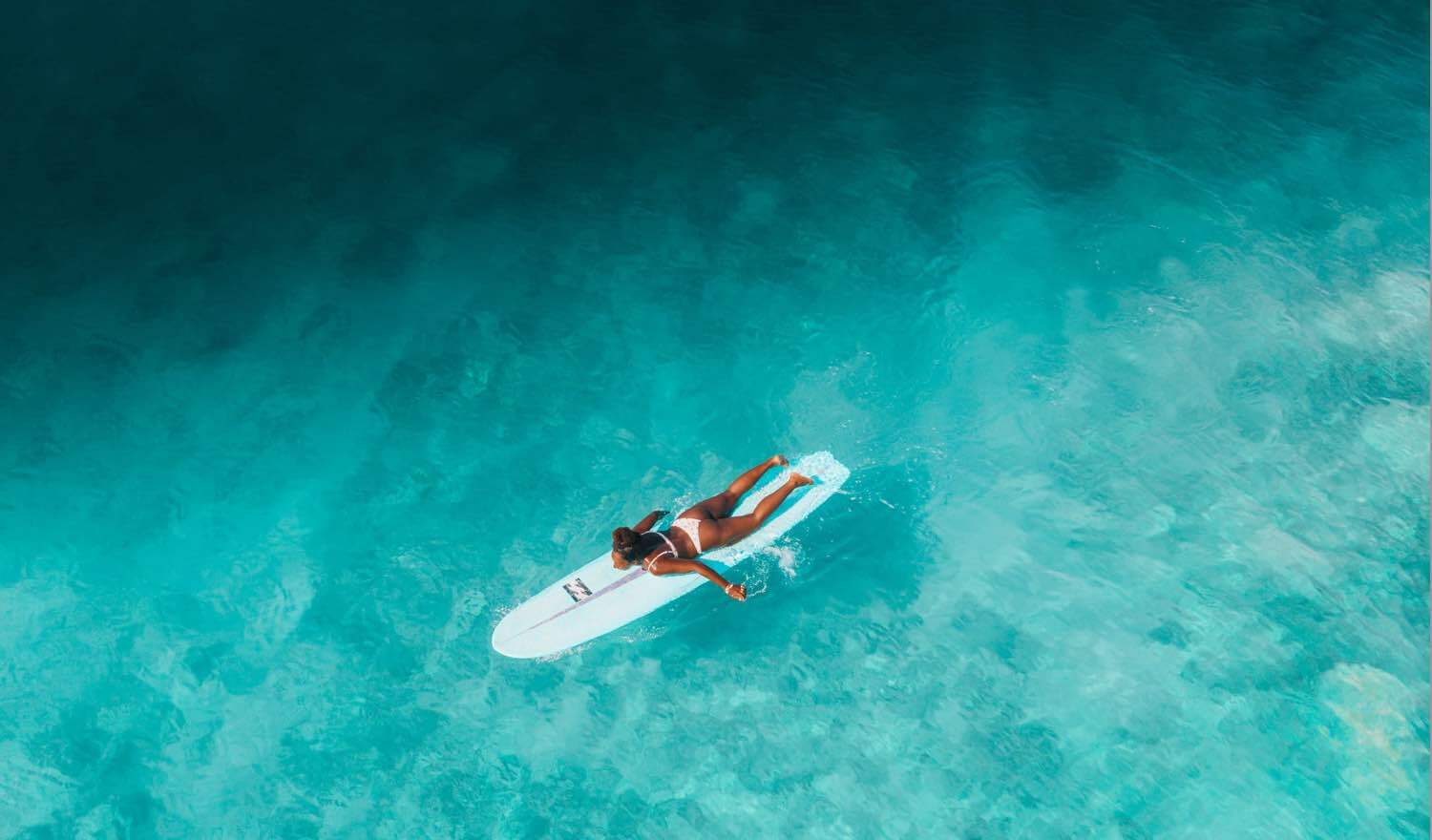 A surfer paddling to catch a wave