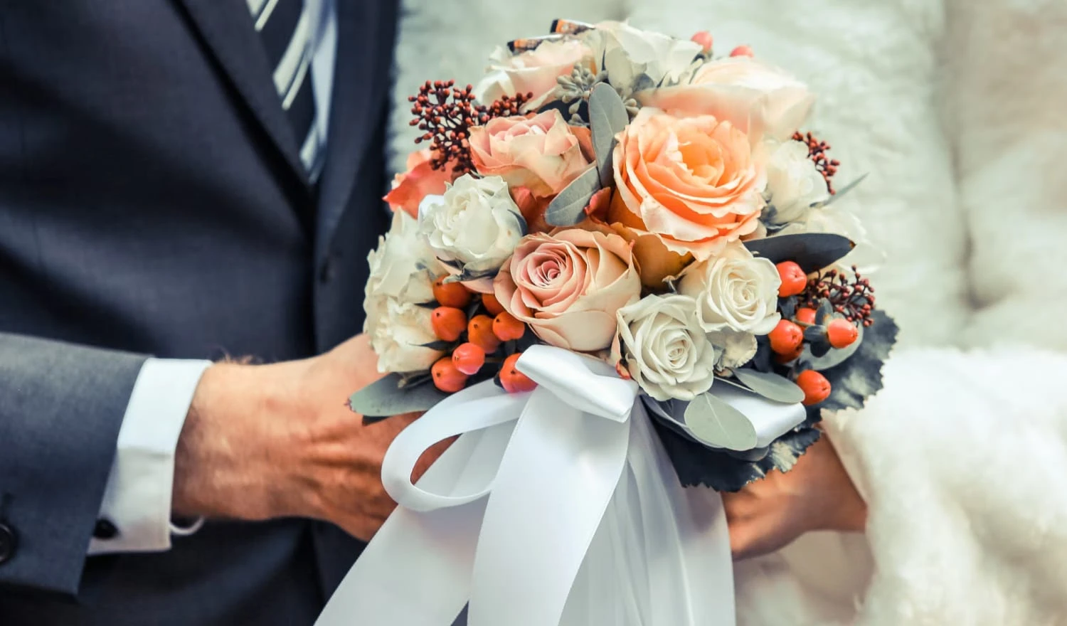 A couple holding a bouquet of flowers