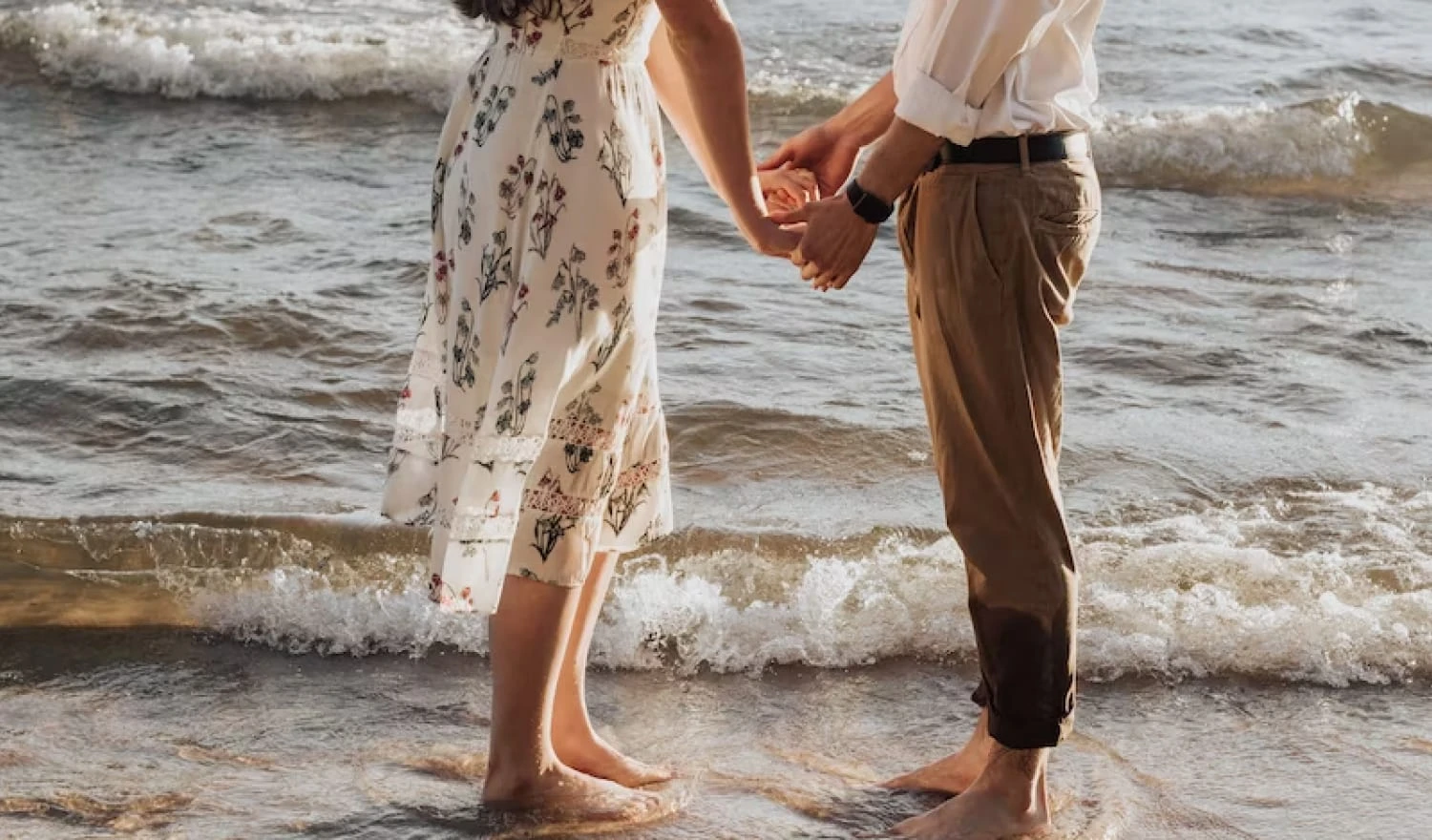 A couple holding hands on the beach