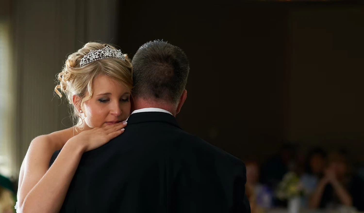 A bride crying on her partners shoulder