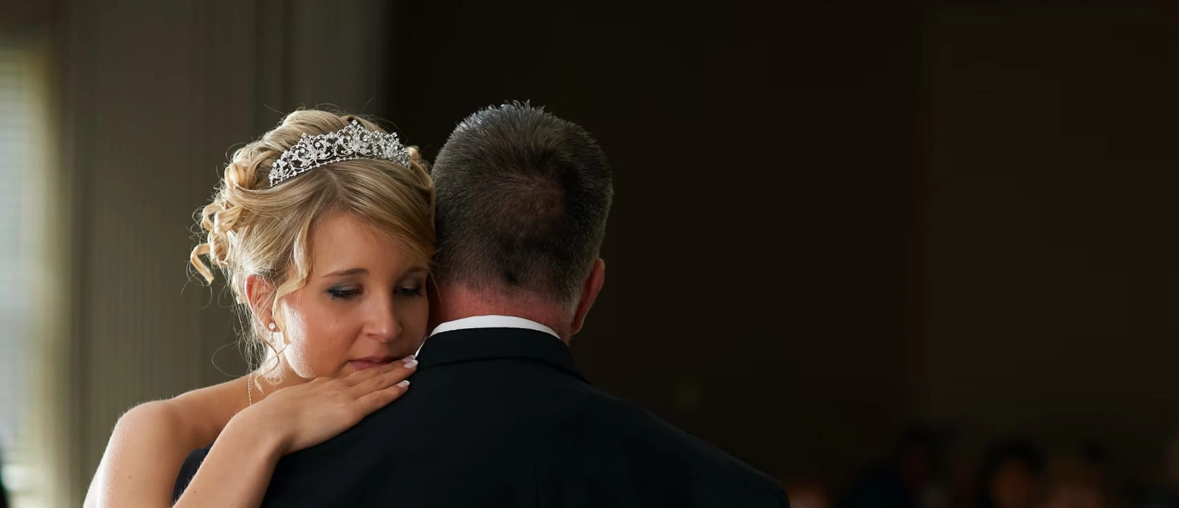 A bride crying on her partners shoulder